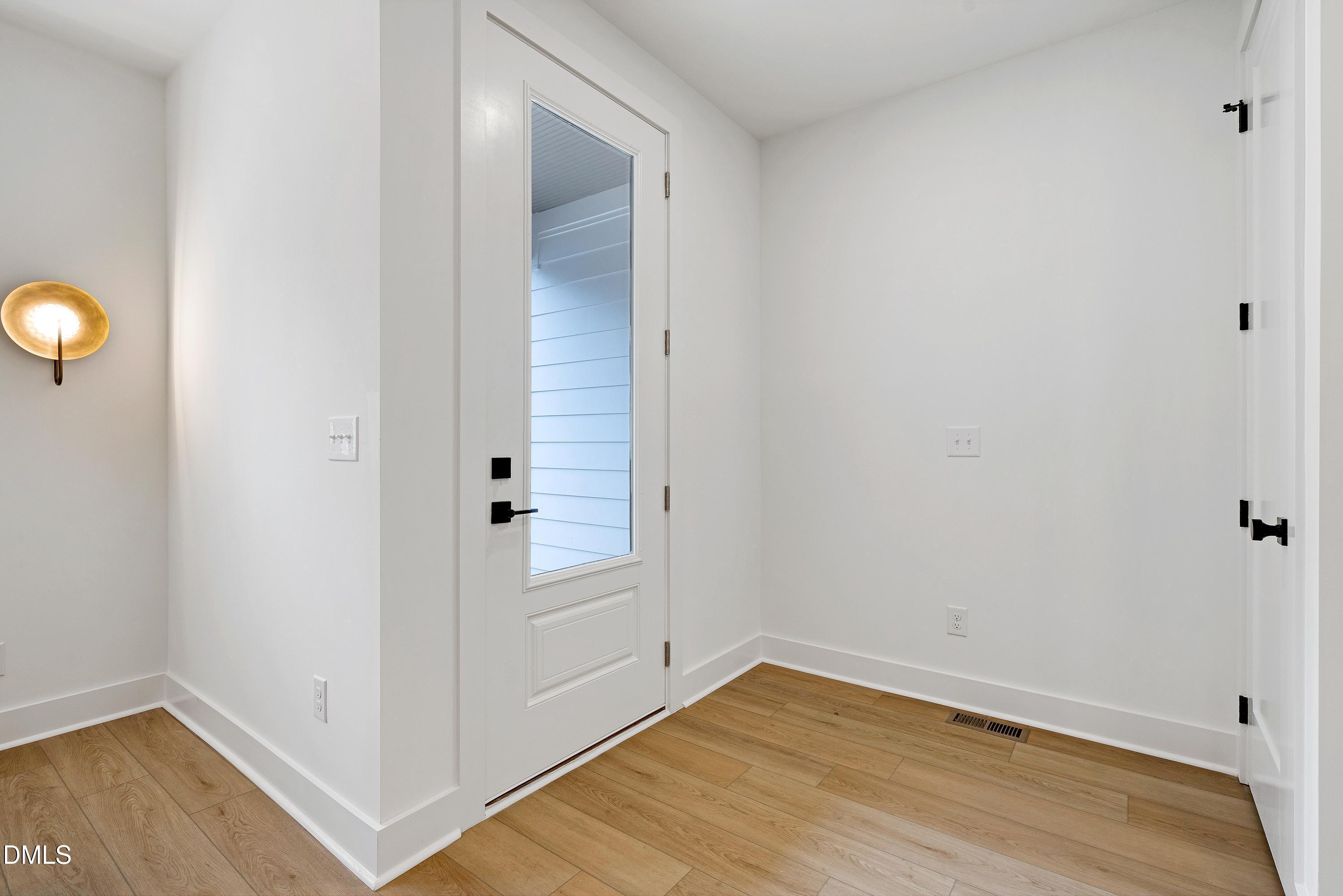 1418 Joe Louis Avenue Raleigh, NC 27610 - Photo 5 of 49 an empty room with wooden floor and mirror