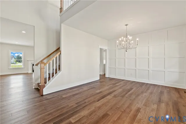 a view of an empty room wooden floor and staircase