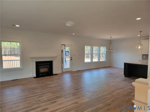 an empty room with windows and fireplace
