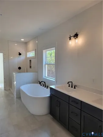 a bathroom with a tub a sink and mirror