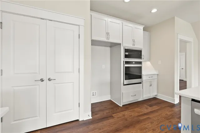 a kitchen with white cabinets and white appliances