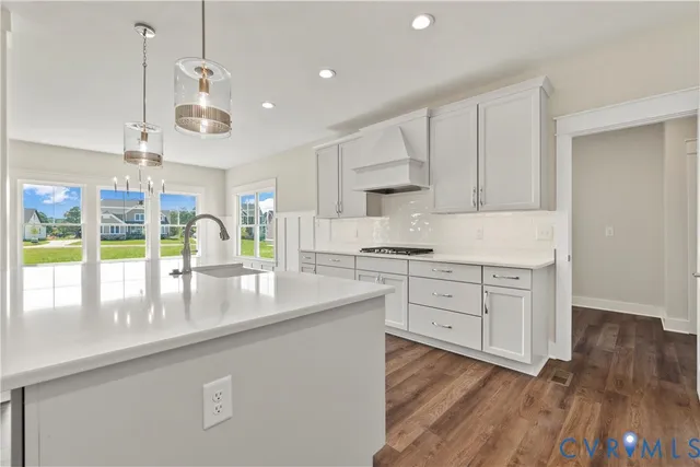 a large kitchen with kitchen island white cabinets and wooden floor