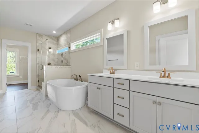 a spacious bathroom with a double vanity sink mirror and bathtub
