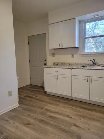 a kitchen with granite countertop white cabinets and white appliances