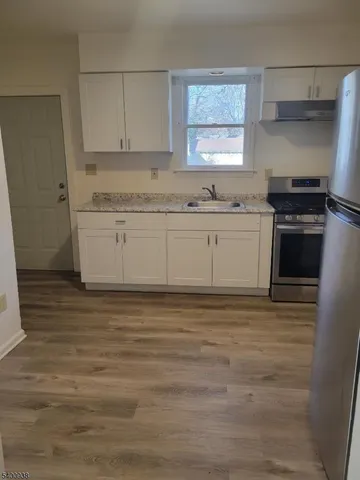 a kitchen with cabinets and wooden floor
