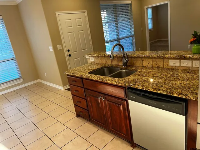 a sink with granite countertop cabinets and sink