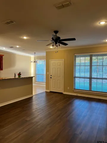 a view of a room with wooden floor and a ceiling fan