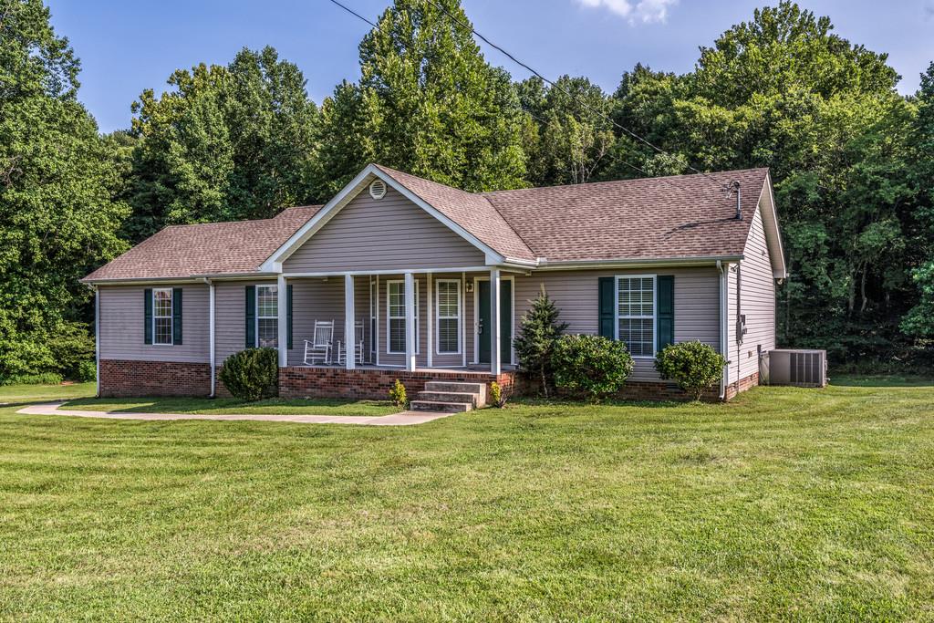 a front view of a house with a garden and trees