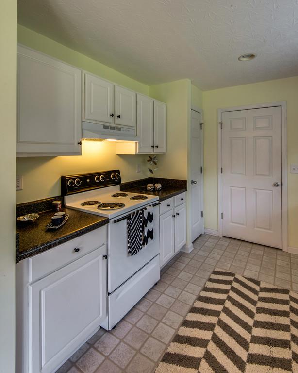 1427 St Paul Road Charlotte, TN 37036 - Photo 14 of 27 a kitchen with granite countertop a stove sink and cabinets