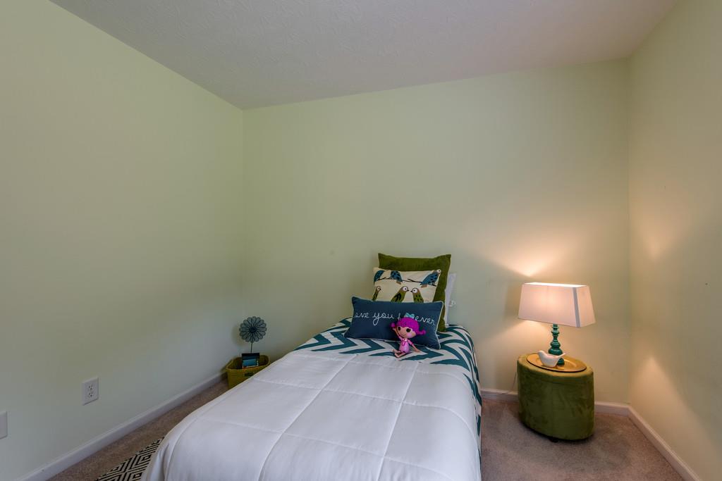 1427 St Paul Road Charlotte, TN 37036 - Photo 20 of 27 a bedroom with a bed and a lamp on dresser