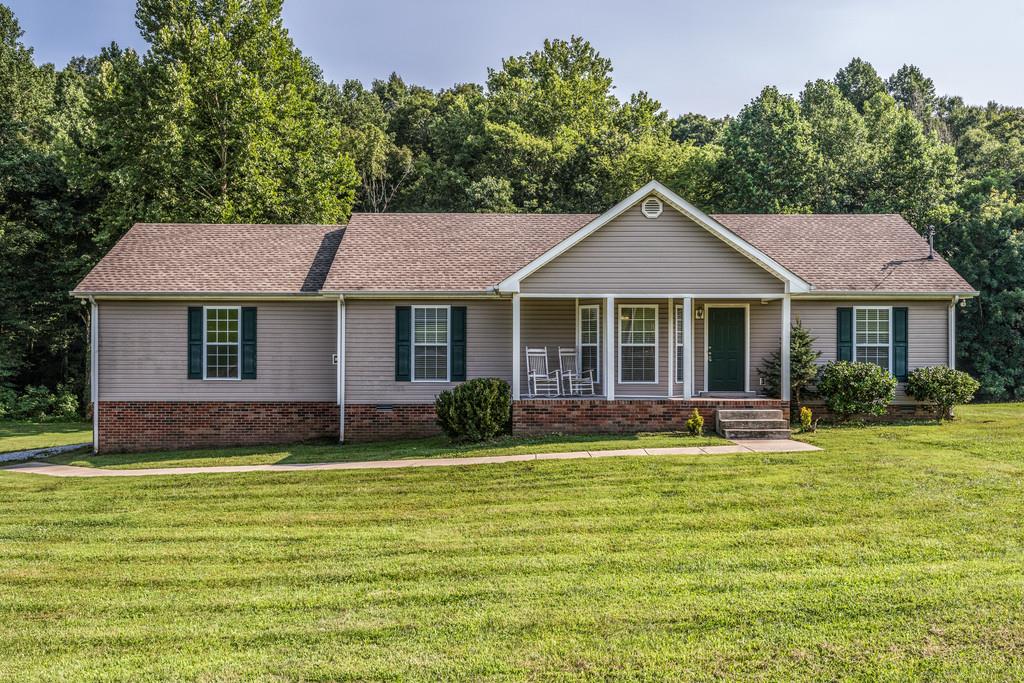1427 St Paul Road Charlotte, TN 37036 - Photo 4 of 27 a front view of a house with a garden and swimming pool