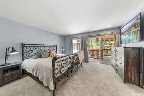 a bedroom with a bed a fireplace and a large window