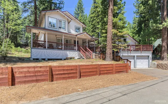 a front view of a house with large trees
