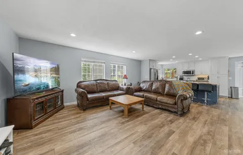 a living room with furniture flat screen tv and wooden floor