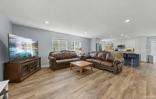 a living room with furniture flat screen tv and wooden floor