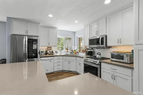 a kitchen with white cabinets stainless steel appliances and sink