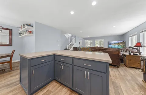 a kitchen with kitchen island granite countertop a sink cabinets and wooden floor