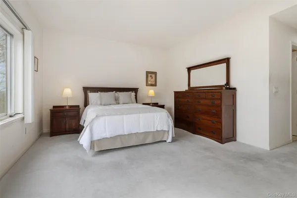 a bedroom with a bed dresser and a large mirror