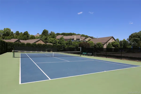 a view of a tennis ground with large trees