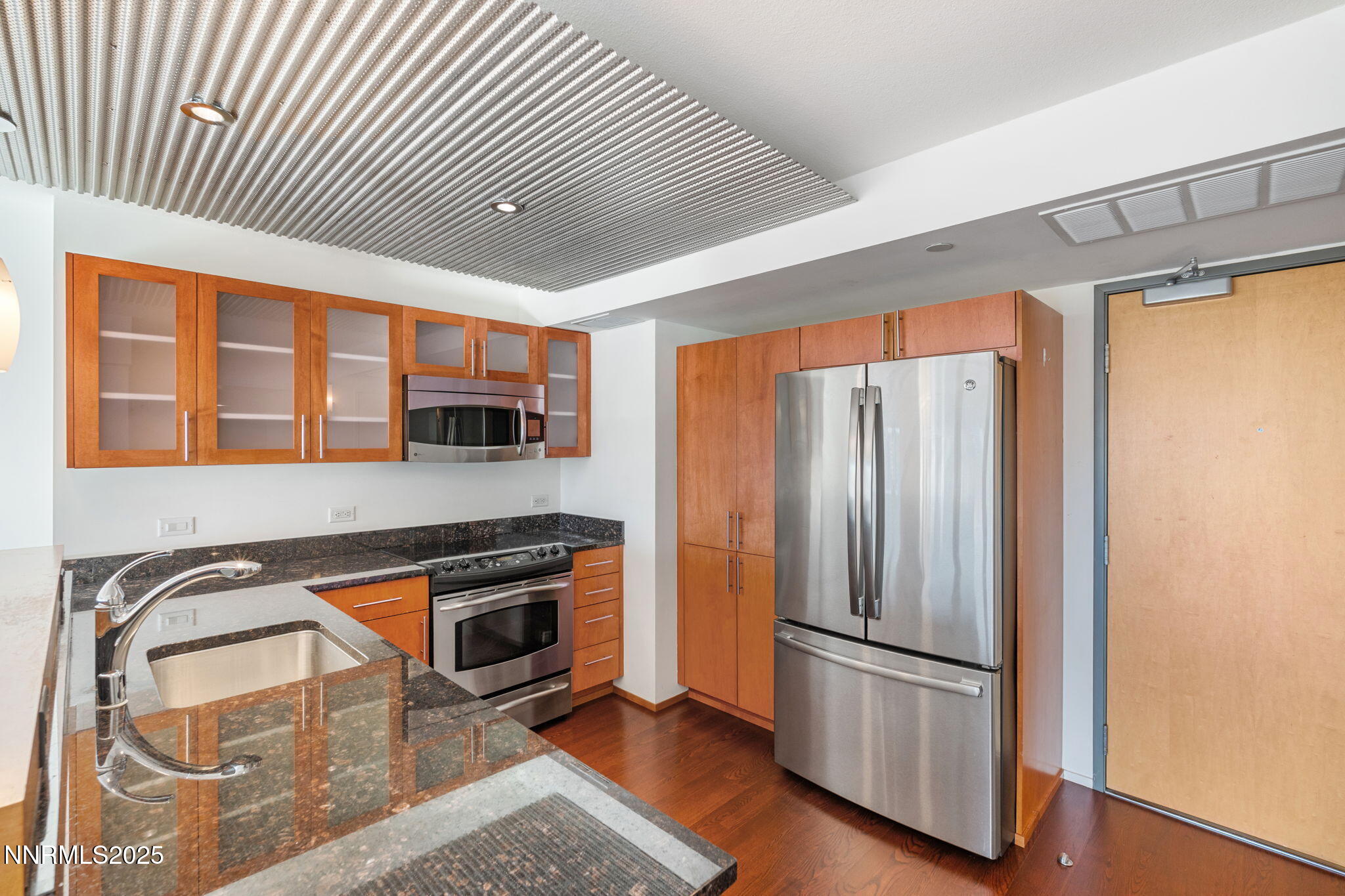 255 North Sierra Street, Unit 1012 Reno, NV 89501 - Photo 4 of 32 a kitchen with stainless steel appliances granite countertop a refrigerator a stove and a sink with wooden floors