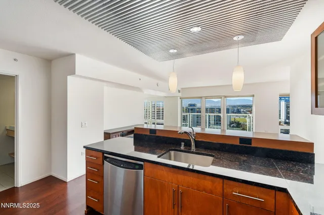 a kitchen with granite countertop a sink and a white wooden cabinets