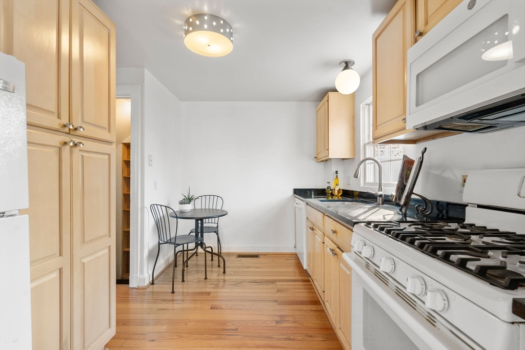 73 Roundwood Road Newton, MA 02464 - Photo 11 of 42 a kitchen with a stove and a wooden floor
