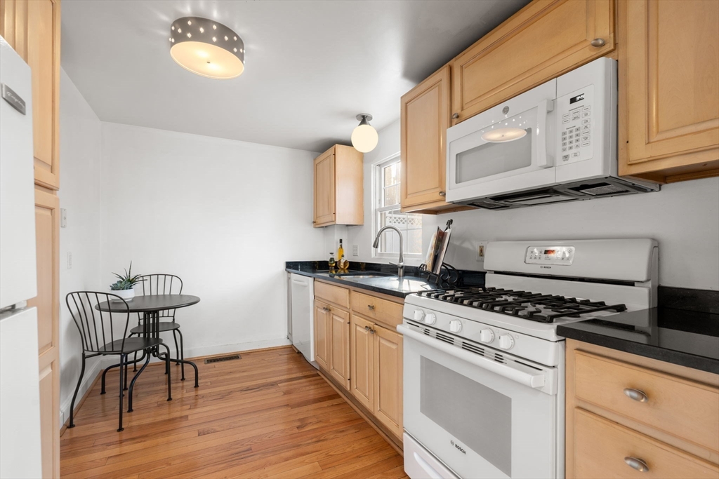 73 Roundwood Road Newton, MA 02464 - Photo 12 of 42 a kitchen with stainless steel appliances granite countertop a stove a sink and a microwave