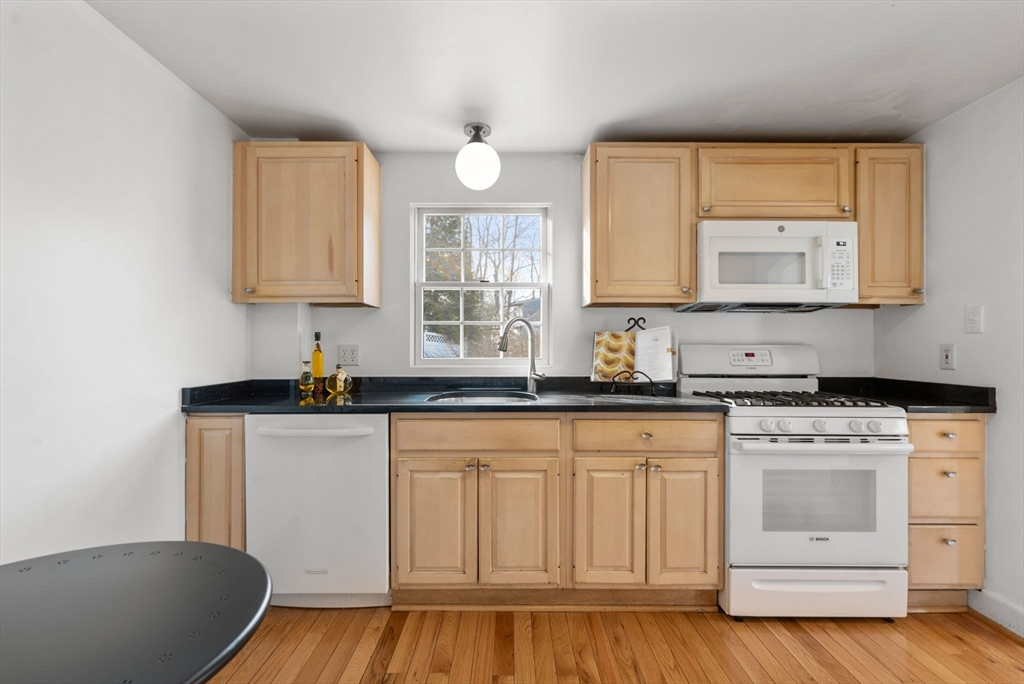 73 Roundwood Road Newton, MA 02464 - Photo 13 of 42 a kitchen with white cabinets and sink
