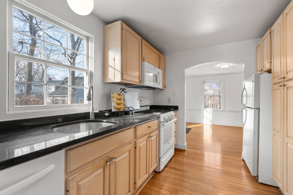 73 Roundwood Road Newton, MA 02464 - Photo 14 of 42 a kitchen with stainless steel appliances granite countertop a stove a sink and a granite counter tops with wooden floors