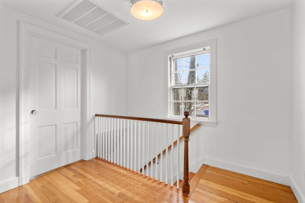 73 Roundwood Road Newton, MA 02464 - Photo 19 of 42 a view of a hallway with wooden floor and windows