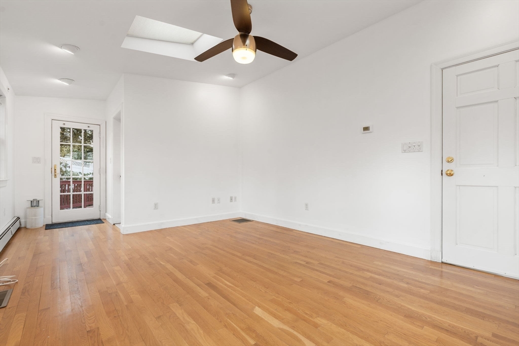 73 Roundwood Road Newton, MA 02464 - Photo 21 of 42 an empty room with wooden floor ceiling fan and windows