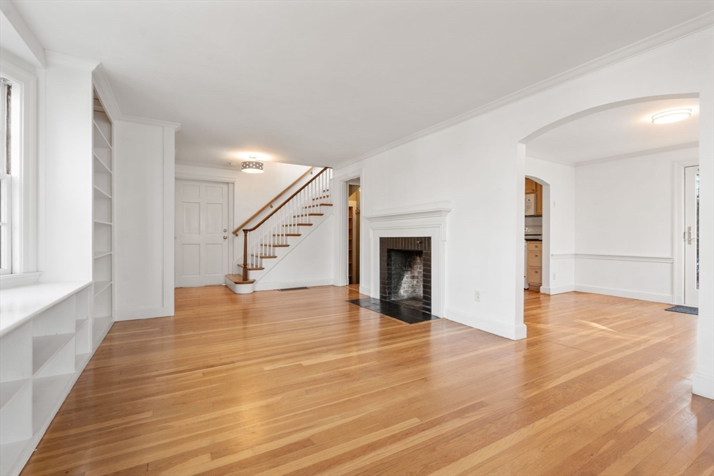 73 Roundwood Road Newton, MA 02464 - Photo 7 of 42 a view of an empty room with wooden floor staircase and a kitchen
