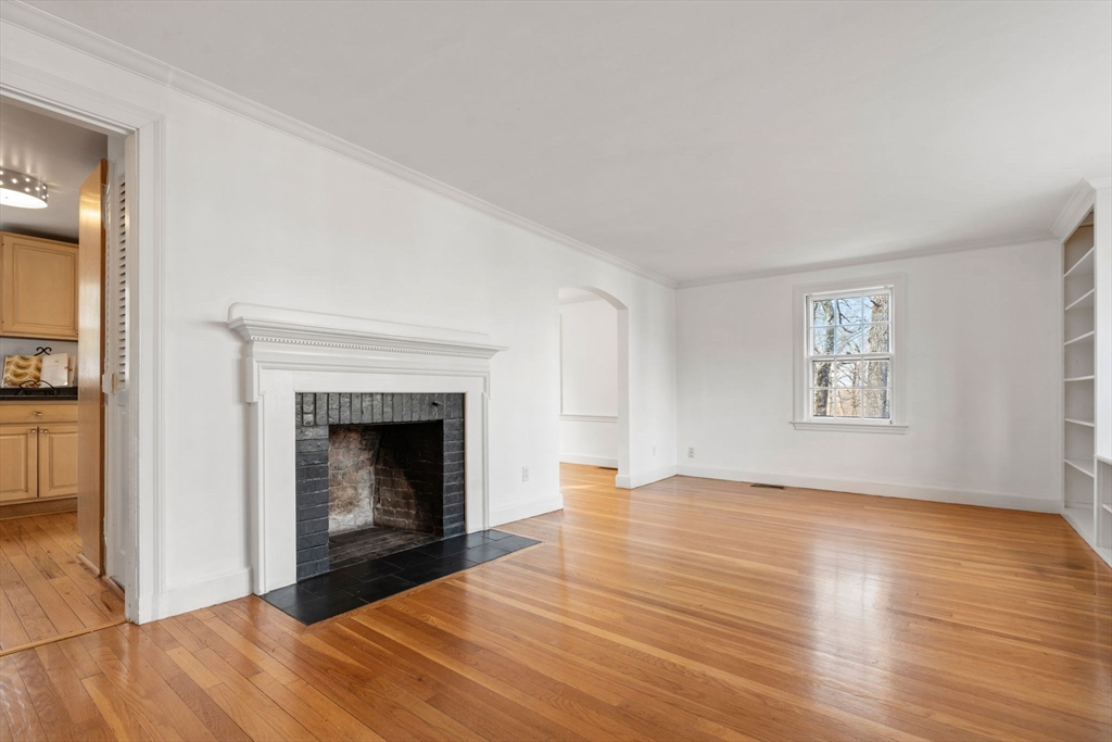 73 Roundwood Road Newton, MA 02464 - Photo 8 of 42 a view of an empty room with wooden floor fireplace and a window
