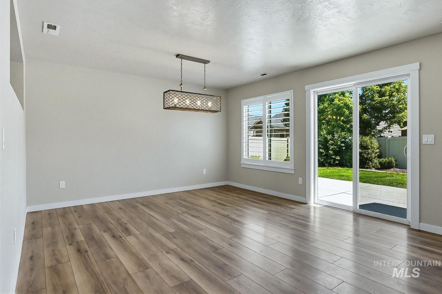 846 North Hidden View Way Star, ID 83669 - Photo 17 of 49 Spacious interior room featuring wood-finish flooring, a modern linear chandelier, and light-toned walls