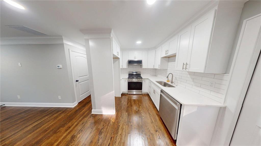 4834 Bartlett Road Forest Park, GA 30297 - Photo 7 of 20 a kitchen with granite countertop a sink and wooden floor