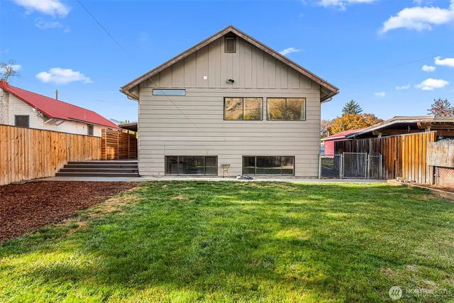 a view of a house with backyard and a tree