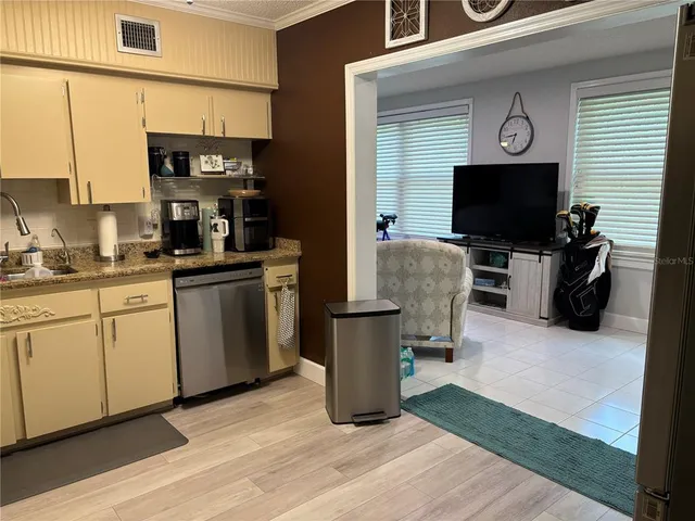 a living room with furniture a flat screen tv and kitchen view