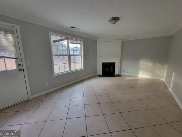 a view of an empty room with a fireplace and a window