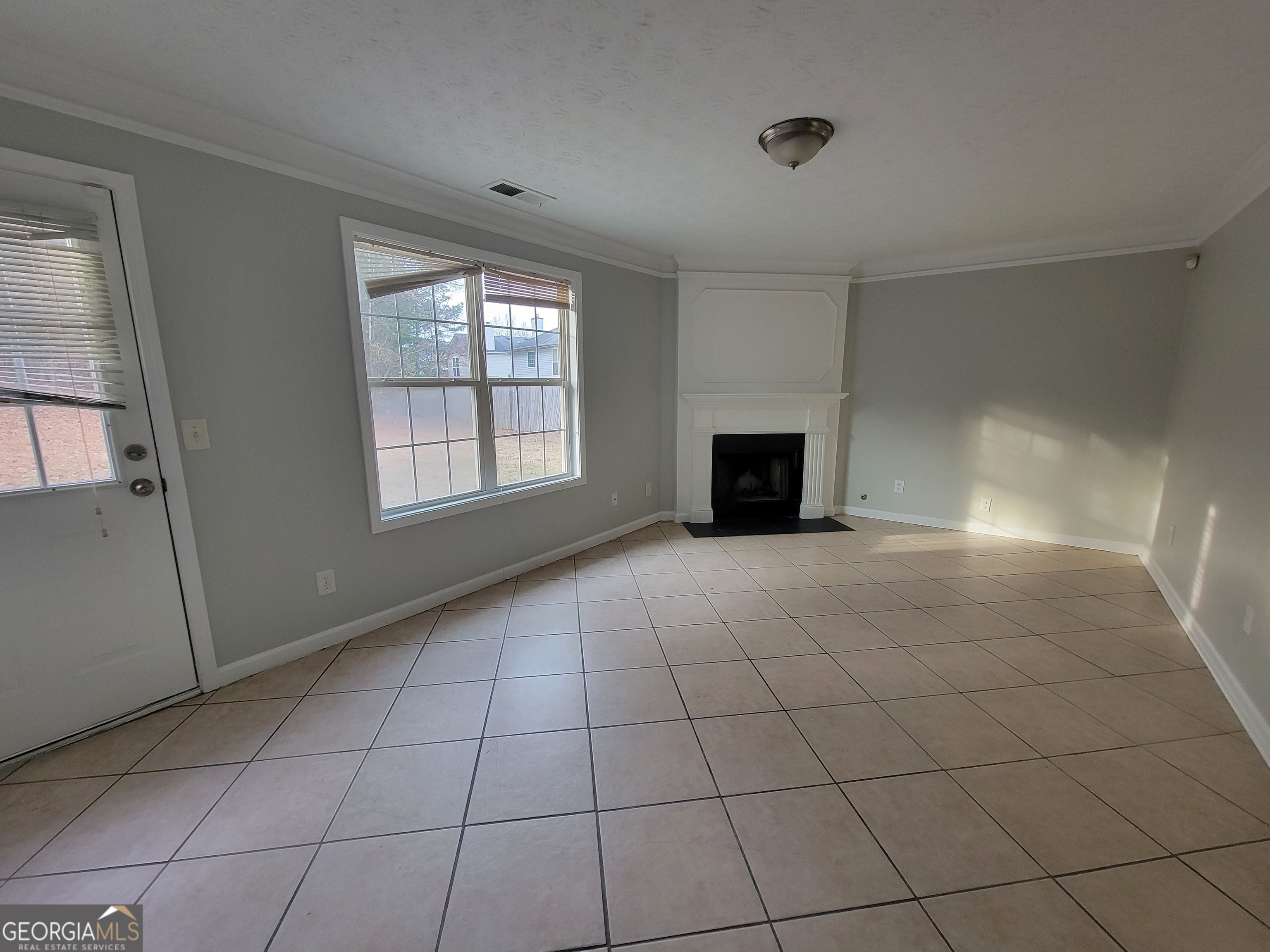 4107 Shining Armor Drive Conley, GA 30288 - Photo 4 of 14 a view of an empty room with a fireplace and a window