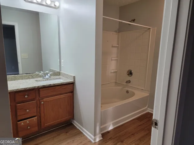 a bathroom with a tub a sink and mirrors