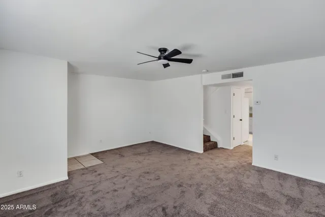 an empty room with closet and a ceiling fan