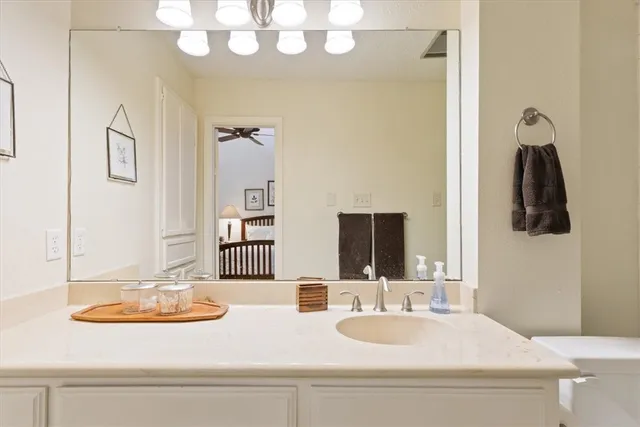 a bathroom with a sink a toilet a mirror and shower