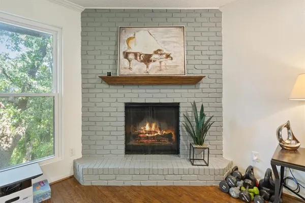 a view of a dining room and livingroom with furniture wooden floor a rug a painting and a chandelier