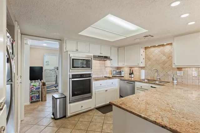 a kitchen with granite countertop cabinets stainless steel appliances and a counter space