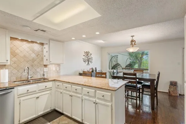 a kitchen with granite countertop a sink and cabinets