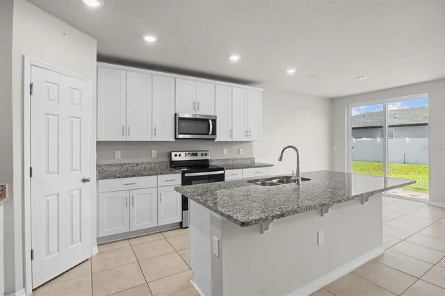 a kitchen with white cabinets a sink and white appliances