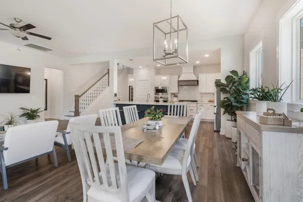 a view of a dining room with furniture a rug and wooden floor
