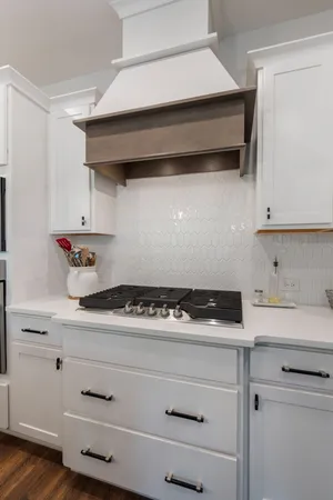 a kitchen with white cabinets and appliances