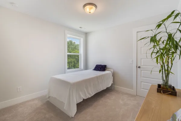 a bed room with a bed and a potted plant