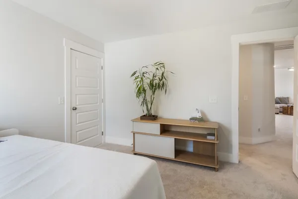 a bedroom with a bed and a potted plant